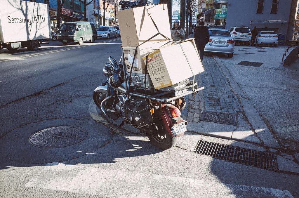A delivery motorcycle in Seoul stacked high with cardboard boxes