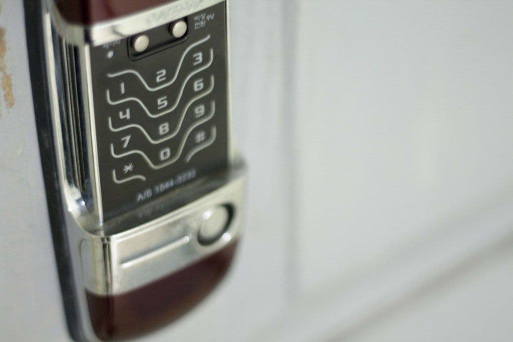 Close-up of a digital keypad door lock on an apartment door